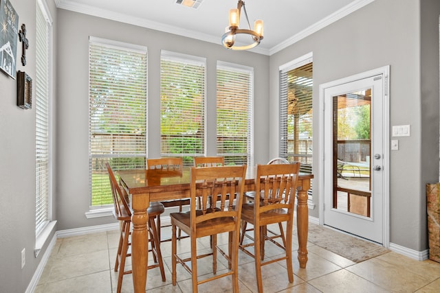 tiled dining area featuring ornamental molding and an inviting chandelier