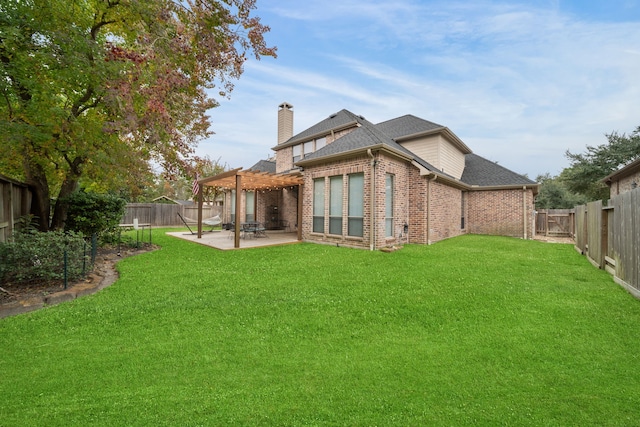 rear view of house featuring a yard, a pergola, and a patio