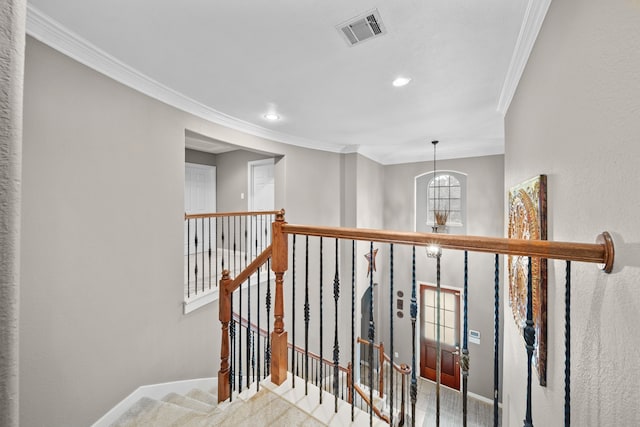 hallway with light carpet, ornamental molding, and a notable chandelier