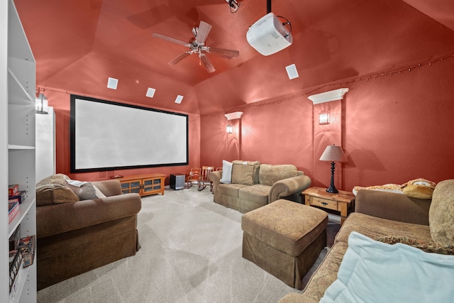 carpeted cinema room with ceiling fan and vaulted ceiling