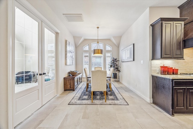 dining area featuring lofted ceiling and french doors