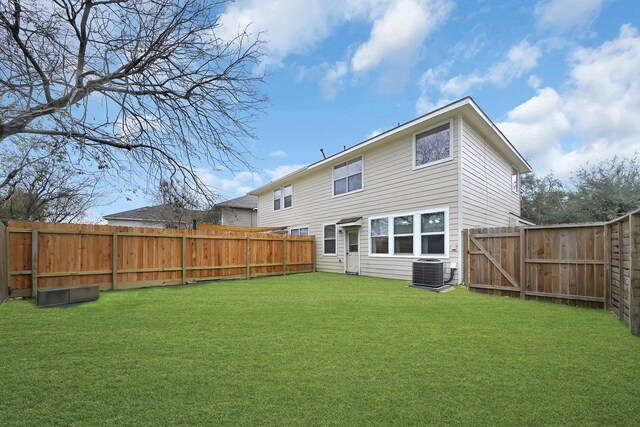 back of property with cooling unit and a yard