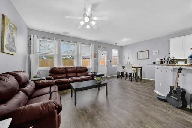 living room featuring ceiling fan and dark wood-type flooring