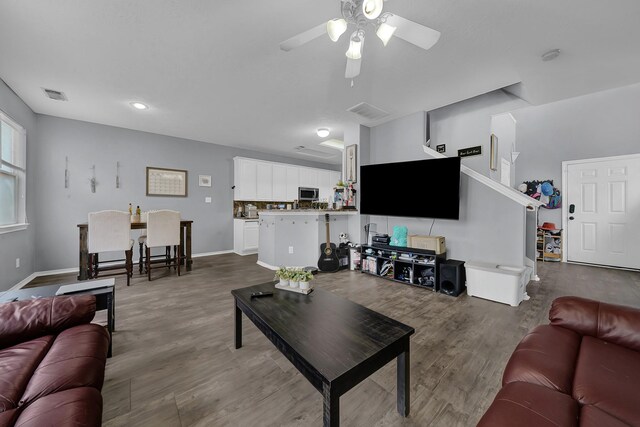 living room featuring ceiling fan and hardwood / wood-style floors