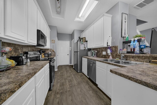 kitchen with appliances with stainless steel finishes, white cabinetry, and sink