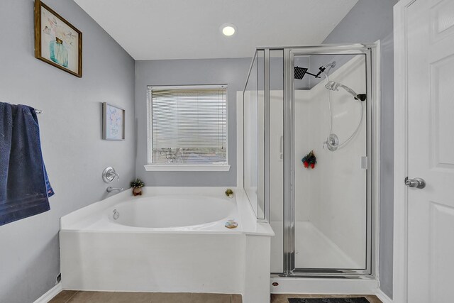 bathroom with shower with separate bathtub and tile patterned floors