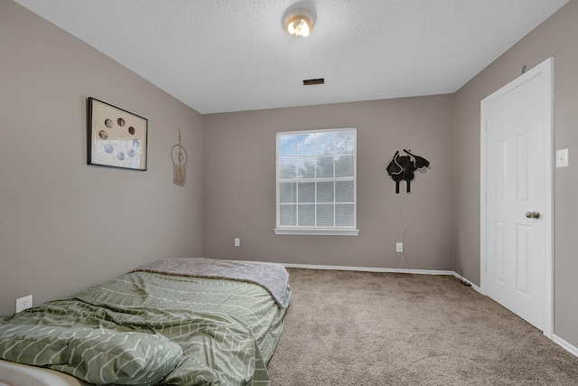 bedroom featuring a textured ceiling and carpet flooring