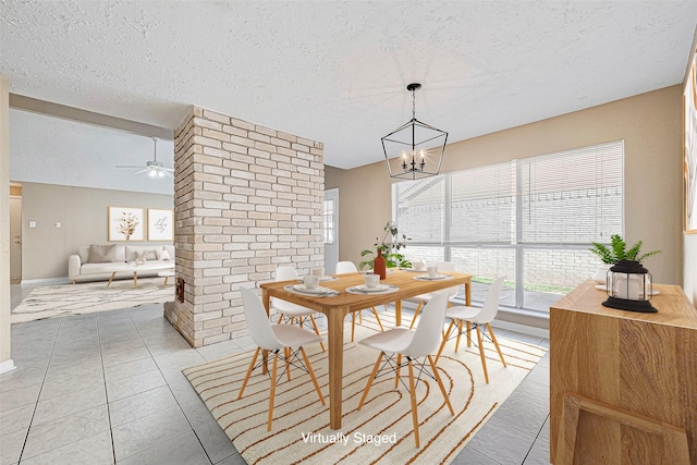 dining area featuring ceiling fan with notable chandelier, a textured ceiling, and light tile patterned floors