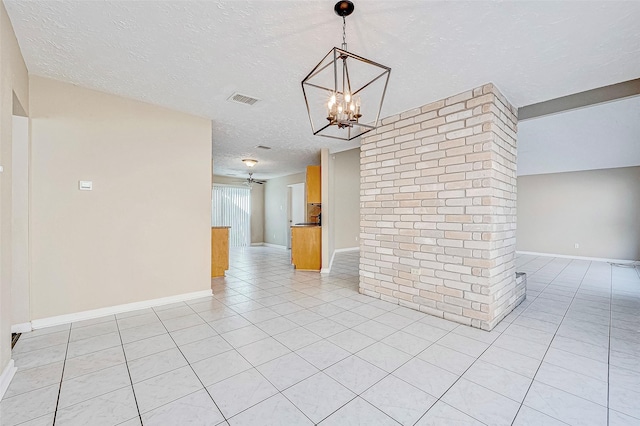 tiled empty room with ceiling fan with notable chandelier and a textured ceiling