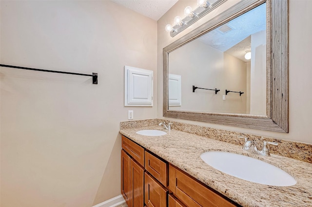 bathroom featuring a textured ceiling and vanity