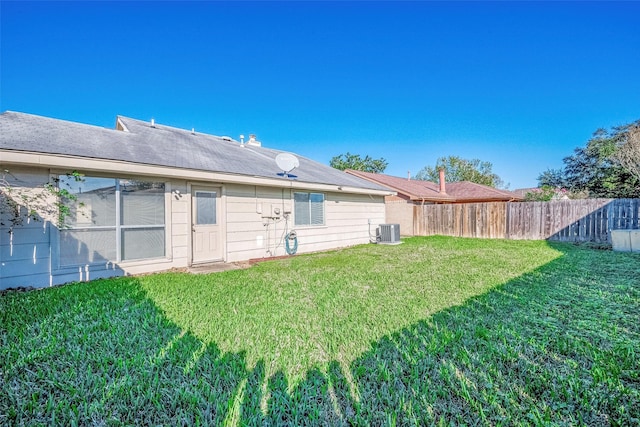 back of property featuring central AC and a lawn