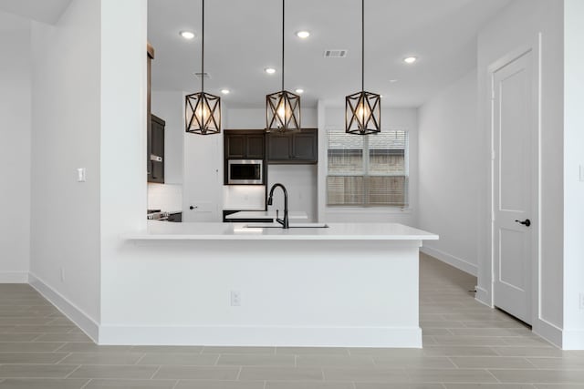 30551 Zoysia Point Ln, Fulshear, TX 77423 - kitchen featuring stainless steel microwave, light countertops, recessed lighting, and pendant lighting