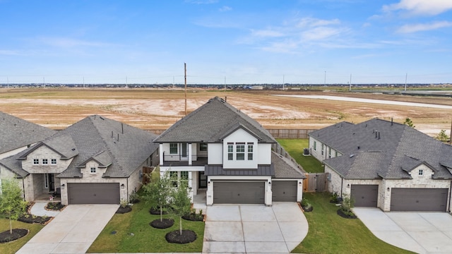 30551 Zoysia Point Ln, Fulshear, TX 77423 - view of front of house with concrete driveway, a shingled roof, a standing seam roof, and stucco siding
