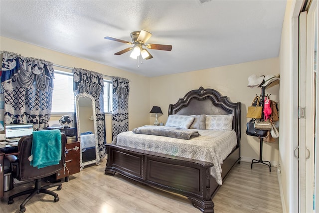 bedroom featuring a textured ceiling, ceiling fan, and light hardwood / wood-style flooring