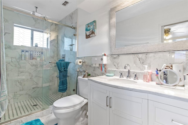 bathroom with vanity, toilet, decorative backsplash, and a shower with shower door