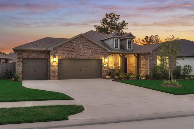 view of front of house featuring a garage and a yard