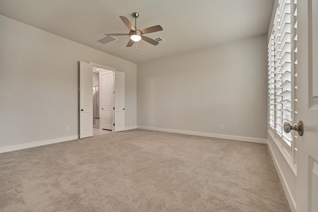 unfurnished room featuring light colored carpet and ceiling fan