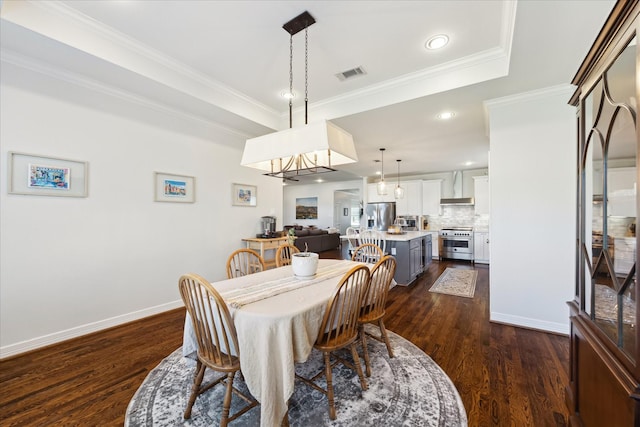 dining space with dark hardwood / wood-style flooring, ornamental molding, and a raised ceiling