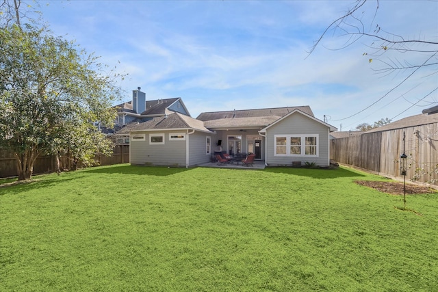 back of house featuring a patio area and a lawn