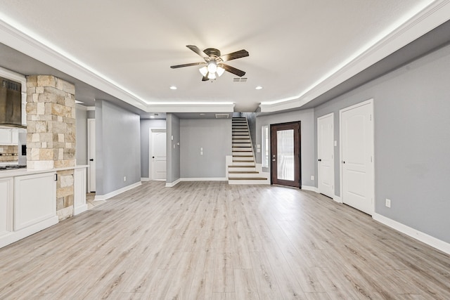 unfurnished living room with a raised ceiling, ceiling fan, and light hardwood / wood-style flooring