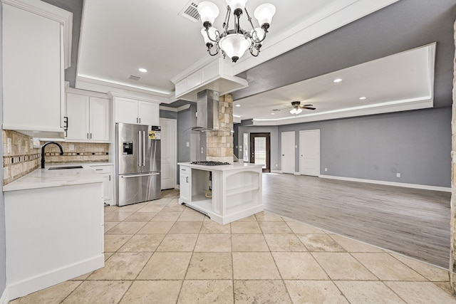 kitchen with white cabinetry, high end refrigerator, sink, light hardwood / wood-style flooring, and ceiling fan with notable chandelier