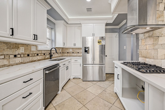 kitchen with light stone counters, appliances with stainless steel finishes, wall chimney exhaust hood, and sink