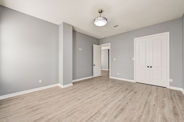 unfurnished bedroom featuring light hardwood / wood-style flooring and a closet