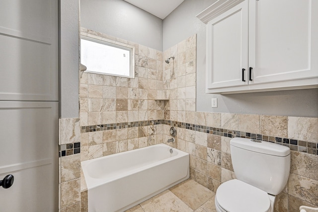 bathroom featuring toilet, tiled shower / bath combo, and tile walls