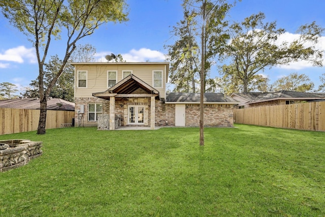 back of property with french doors and a lawn