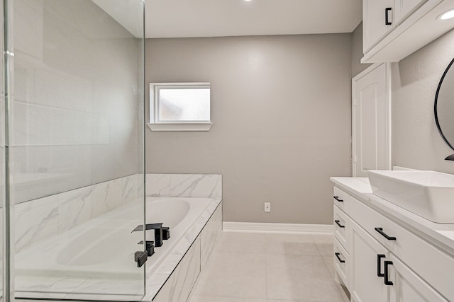 bathroom featuring vanity, tile patterned floors, and a relaxing tiled tub