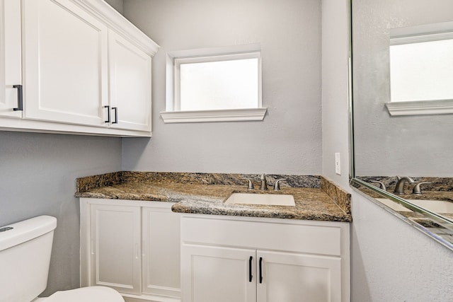 bathroom featuring toilet and vanity