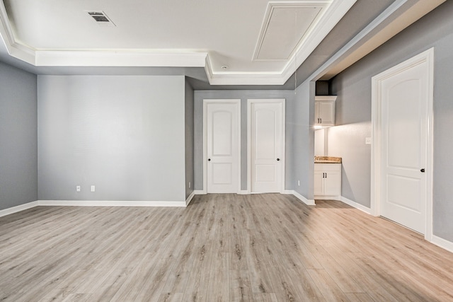 unfurnished bedroom with light hardwood / wood-style floors, connected bathroom, and a raised ceiling