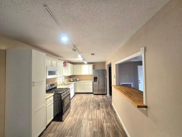 kitchen with sink, white cabinetry, a textured ceiling, track lighting, and appliances with stainless steel finishes