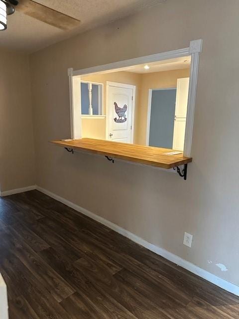 spare room with ceiling fan and dark wood-type flooring