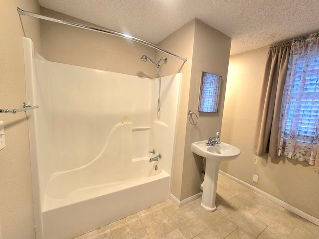 bathroom featuring a textured ceiling and  shower combination