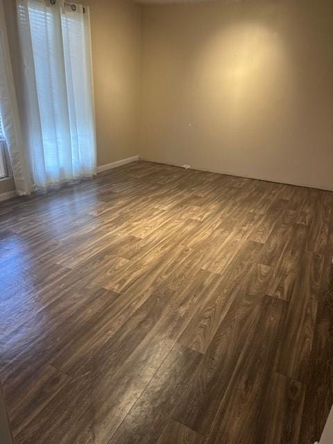 unfurnished room featuring dark wood-type flooring