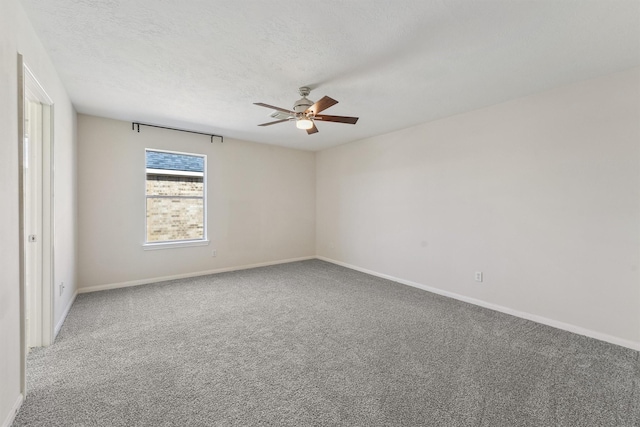 empty room with ceiling fan, carpet, and a textured ceiling