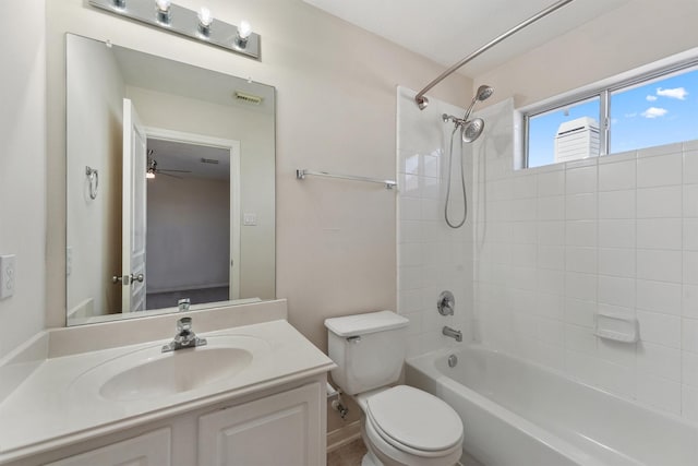 full bathroom with ceiling fan, tiled shower / bath, vanity, and toilet