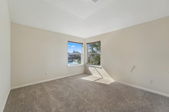 carpeted empty room featuring a water view