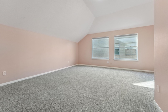 additional living space featuring carpet flooring and vaulted ceiling