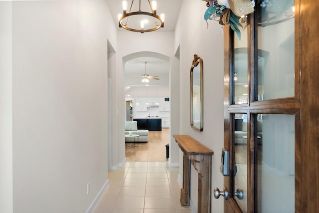 hallway featuring a notable chandelier and light tile patterned flooring