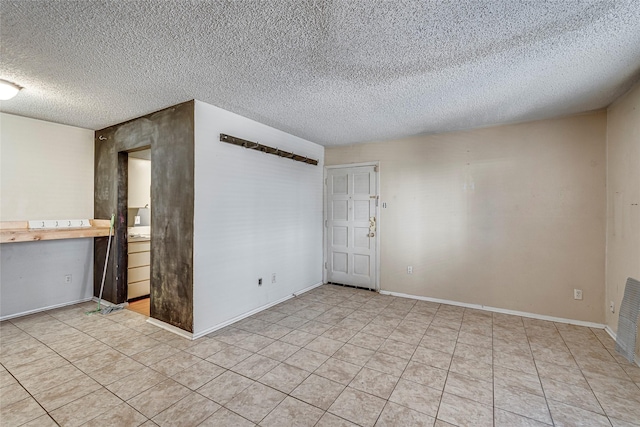 unfurnished room featuring a textured ceiling and light tile patterned flooring