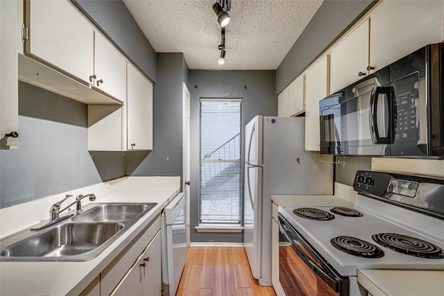 kitchen featuring sink, white appliances, white cabinetry, and a textured ceiling