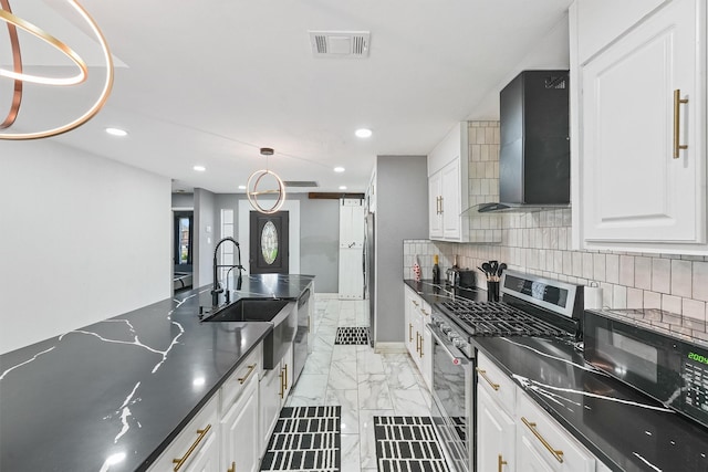 kitchen with wall chimney exhaust hood, white cabinetry, tasteful backsplash, sink, and stainless steel range with gas cooktop