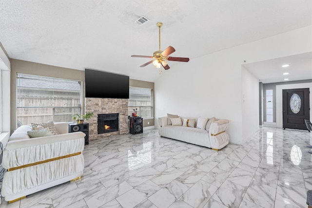 living room featuring a textured ceiling, ceiling fan, vaulted ceiling, and plenty of natural light