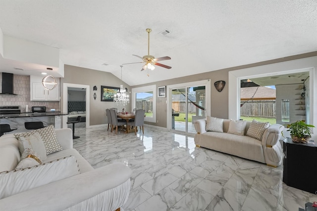 living room featuring ceiling fan with notable chandelier, a textured ceiling, and lofted ceiling