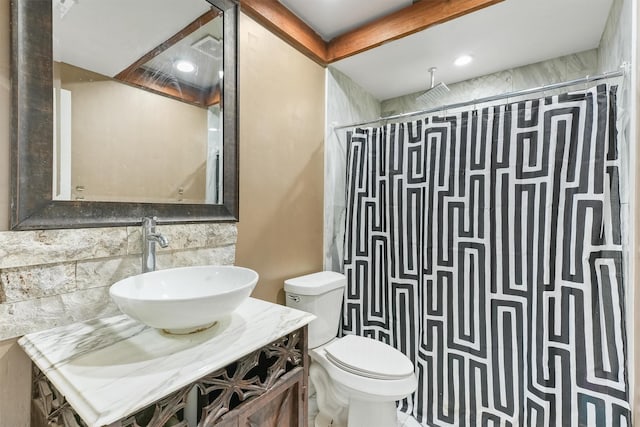 bathroom featuring toilet, curtained shower, tasteful backsplash, and sink