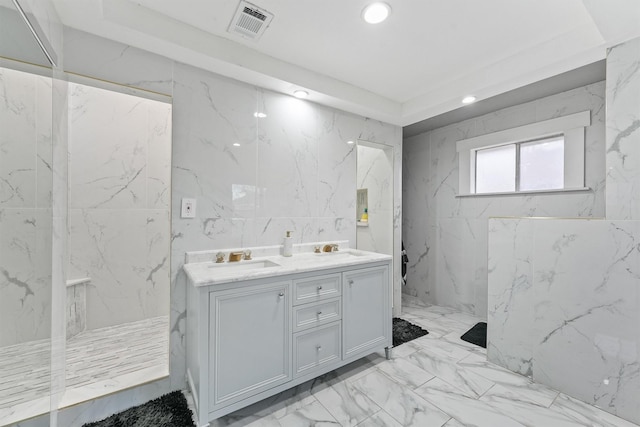 bathroom with vanity, tile walls, and a shower