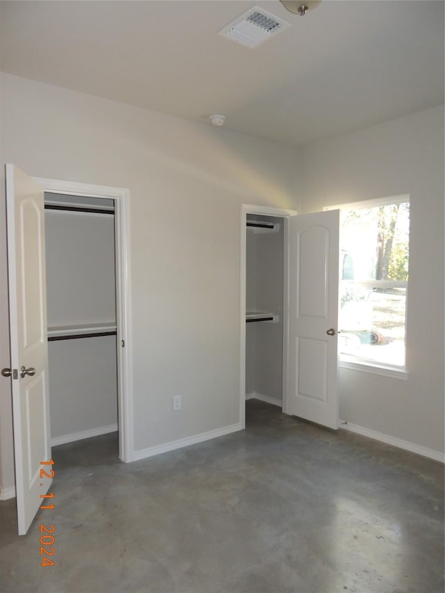 unfurnished bedroom with concrete flooring