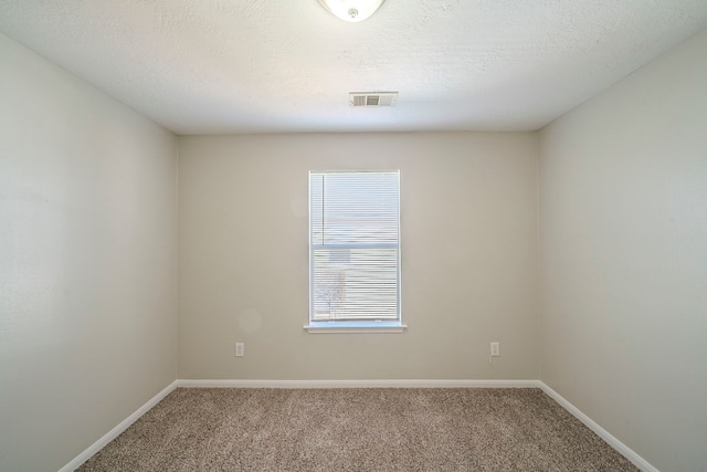 spare room featuring a textured ceiling and carpet